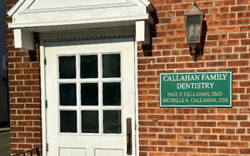 The image shows a sign on a brick building with a white door frame, indicating  Callahan Family Dentistry  and a plaque below it stating  Parker A. Callahan, DMD.