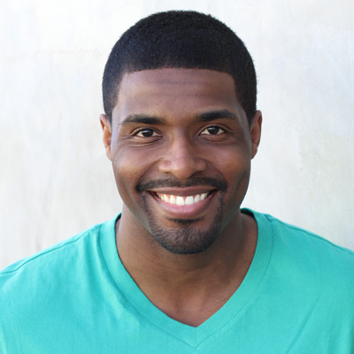 An elderly couple posing for a photo with smiles, embracing each other warmly.
